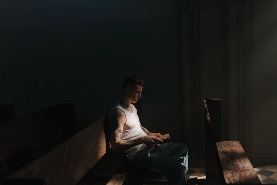 Tattooed man reading dim light
