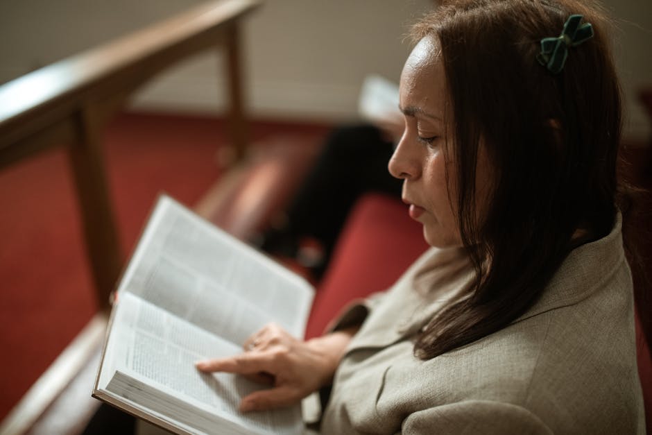 Woman reading bible in pew